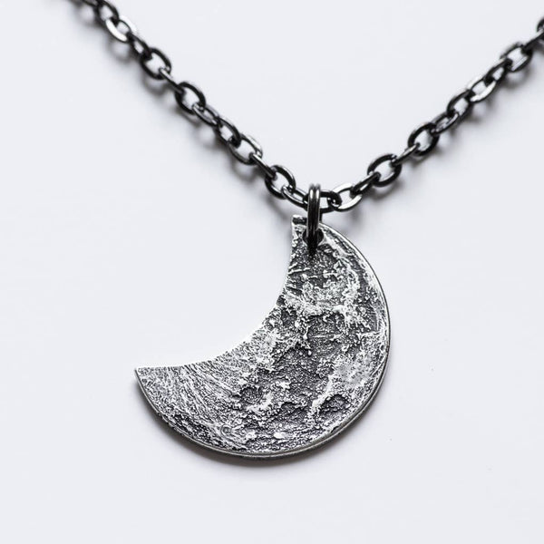 Fine silver double-sided crescent moon coin pendant necklace - the perfect moon gift! Showing near side of the Moon with black chain.